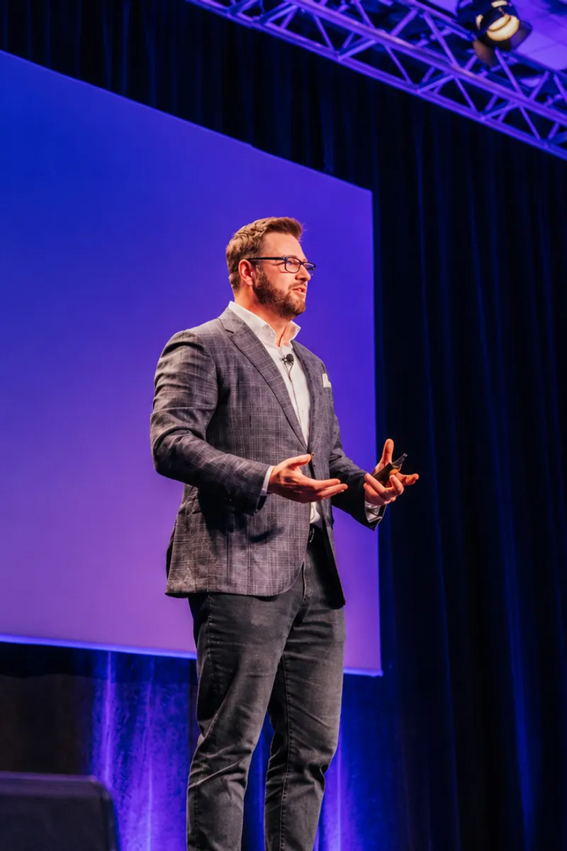 A Top Down CPM consultant speaking on stage at a finance conference.